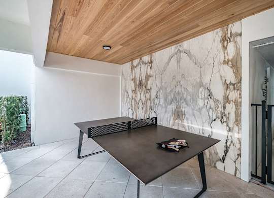 a ping pong table in the pool area of the home