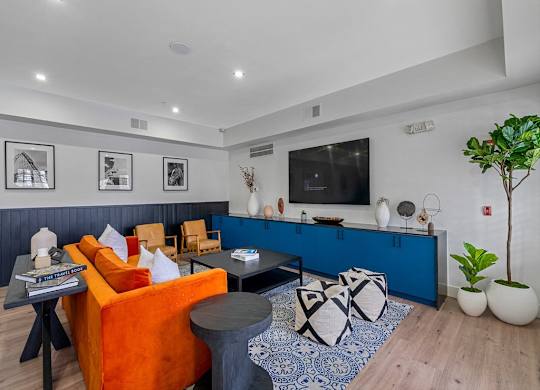 a living room with a blue and orange couch and a television