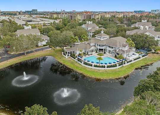 an aerial view of the clubhouse with a pool and water fountain