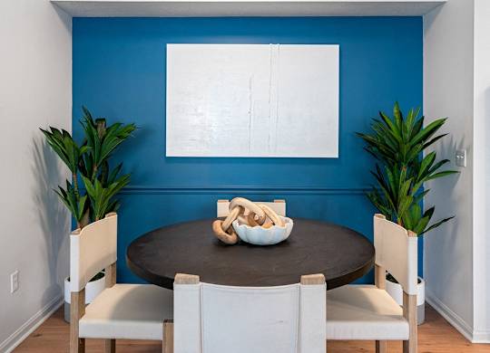 a dining room with a blue wall and a table and chairs