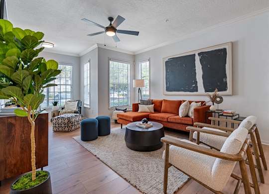 a living room with a orange couch and a ceiling fan