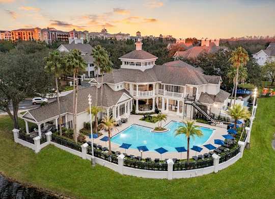an aerial view of a mansion with a large swimming pool
