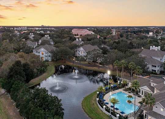 an aerial view of a swimming pool and fountain at sunset
