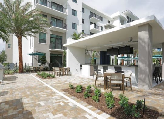 a patio with tables and chairs in front of a building