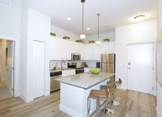 a kitchen with an island and a stainless steel refrigerator