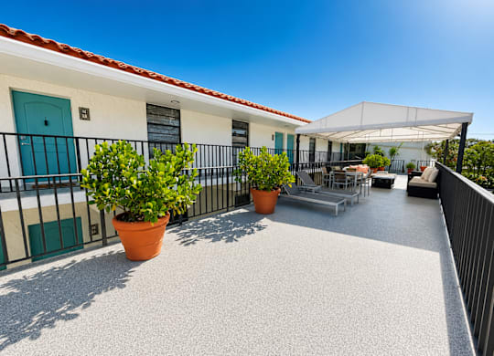 A patio with a table and chairs under a white awning.