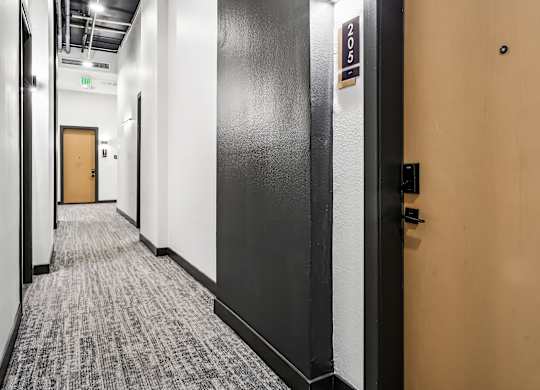 A hallway with a door on the right and a sign on the wall.