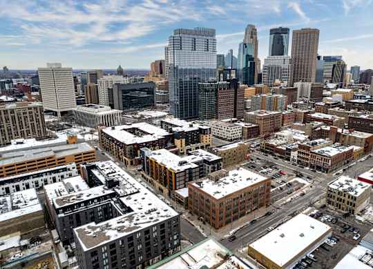 A cityscape with buildings and snow on the ground.