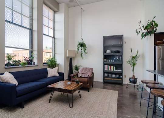 A living room with a blue couch, a wooden coffee table, and a bookshelf.