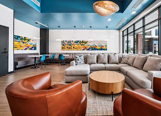 A living room with a brown leather chair and a grey sofa.