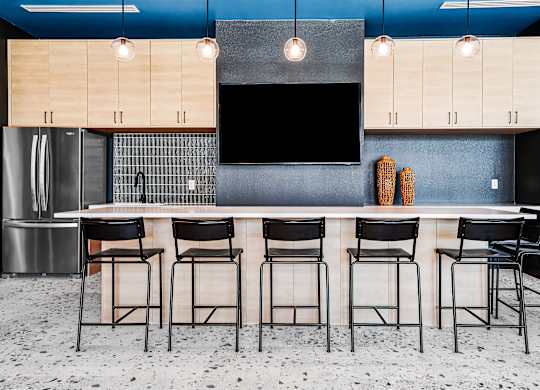 A kitchen with a bar area featuring a counter and chairs.