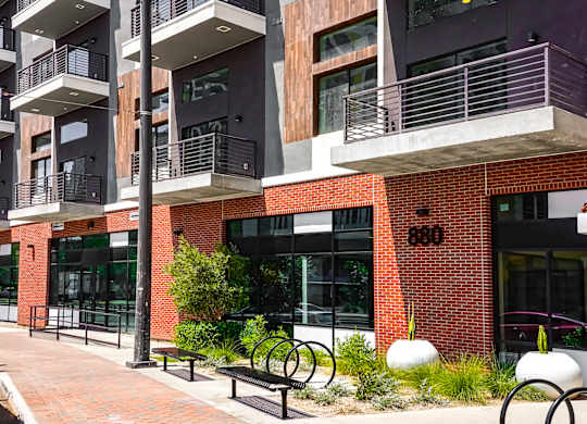 A modern building with balconies and a brick facade.