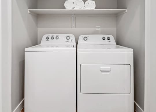 Two white washing machines in a laundry room.