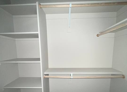 a small closet with a window in a white room
