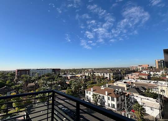 a balcony with a view of the city and palm trees