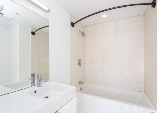 a bathroom with a sink and a tub and a mirror