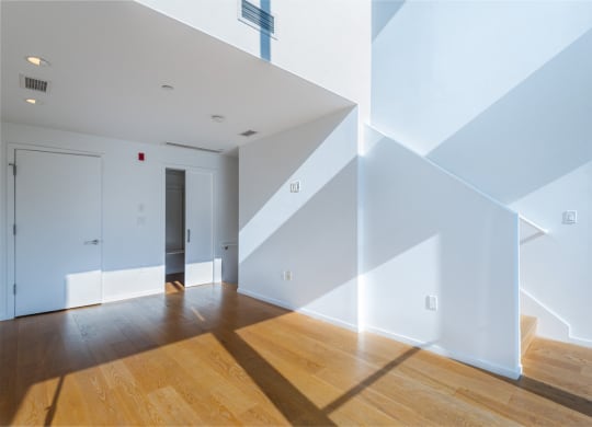 a living room with white walls and wooden floors