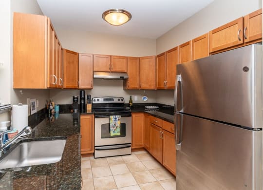 50 WB's furnished apartment showing full kitchen with stainless steel appliances and granite counter tops