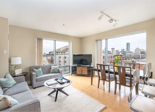 50 WB's furnished apartment showing a living room with a couch and a table and a large window