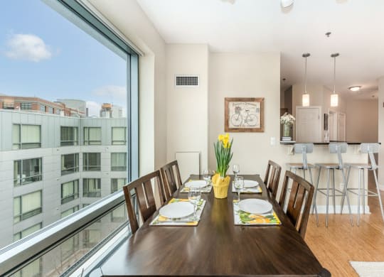 50 WB's furnished apartment showing a dining room with a large window and a table with chairs