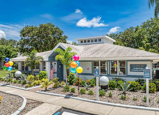 a blue building with balloons in front of it at Aqua Bay Apartments in Naples, FL 34116