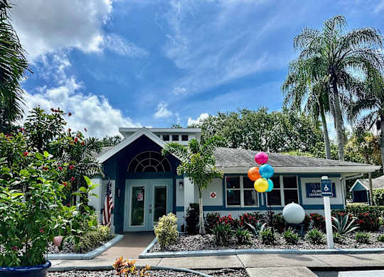 a blue house with colorful balloons in front of it at Aqua Bay Apartments in Naples, FL 34116