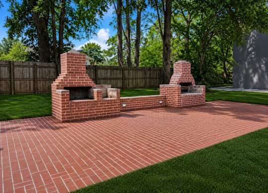 Two brick fire pits in a backyard.