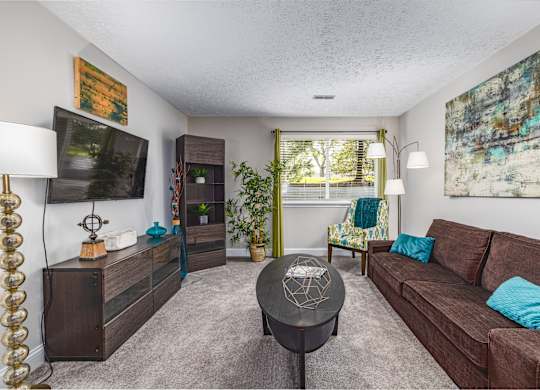 A living room with a brown couch and a black coffee table.
