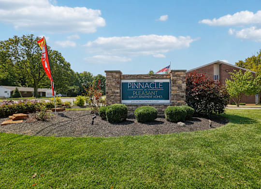 The entrance to Pinnacle Assisted Living with a sign and a flag.