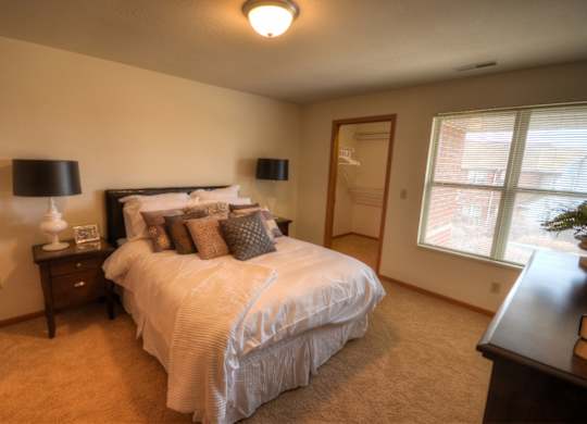 a bedroom with a large bed and a window
