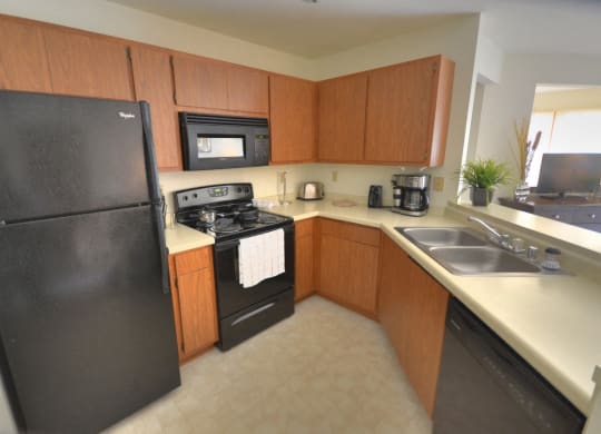 a kitchen with black appliances and wooden cabinets