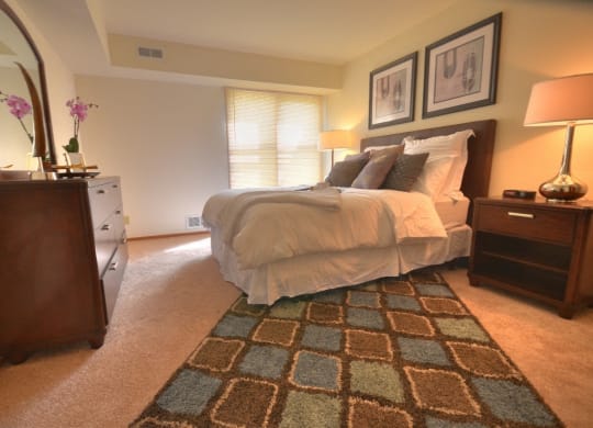a bedroom with a bed and a dresser and a mirror