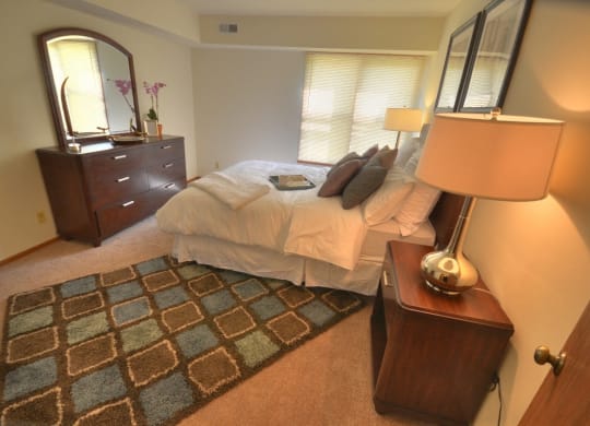 a bedroom with a bed and a dresser and a mirror