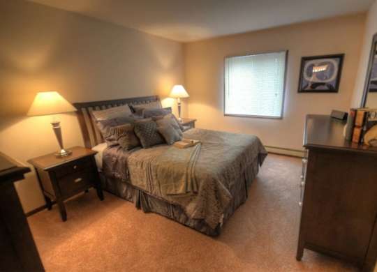 a bedroom with a bed and a dresser and a window