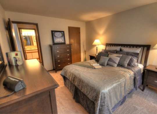 a bedroom with a bed and a dresser and a mirror