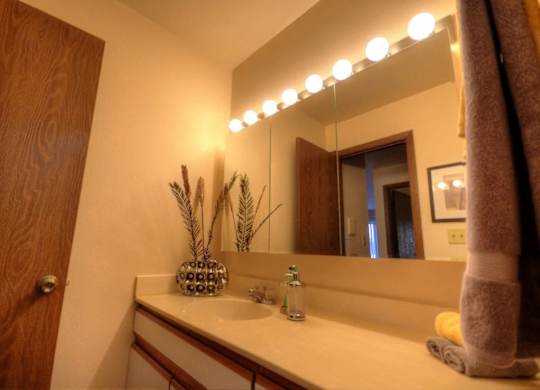 the bathroom has a large mirror and a sink