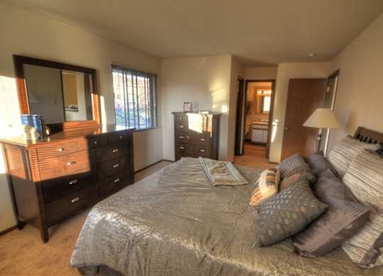 a bedroom with a bed and a dresser and a mirror