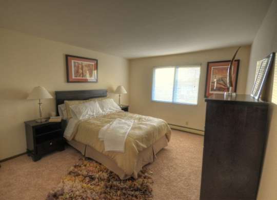 a bedroom with a bed and a dresser and a window
