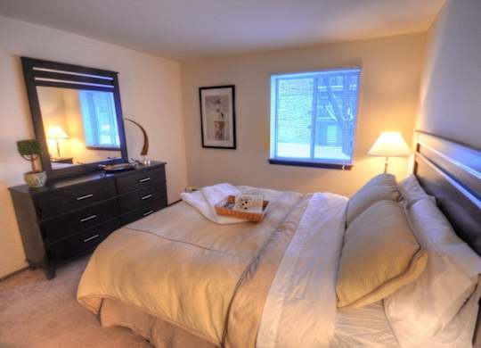 a bedroom with a bed and a dresser and a window