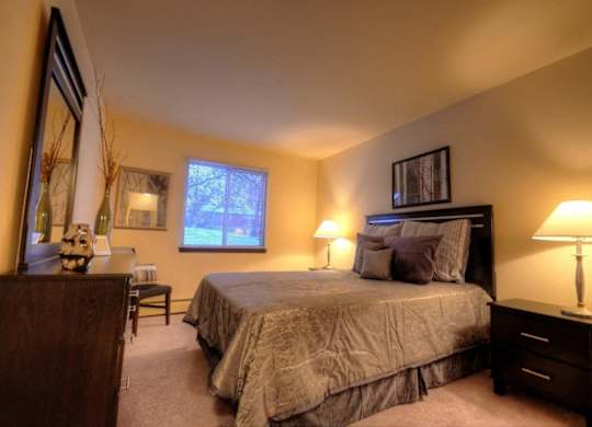 a bedroom with a large bed and a desk