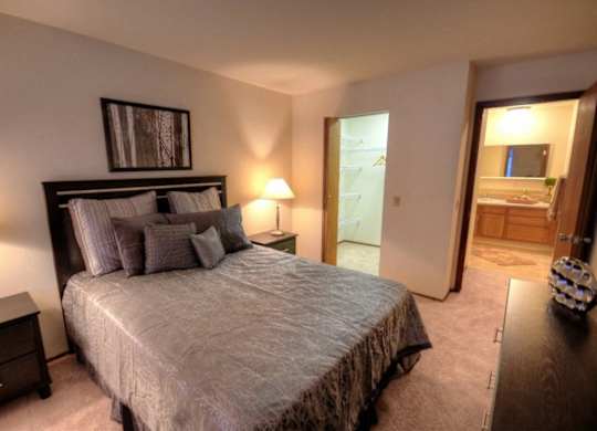 a bedroom with a large bed and a bathroom