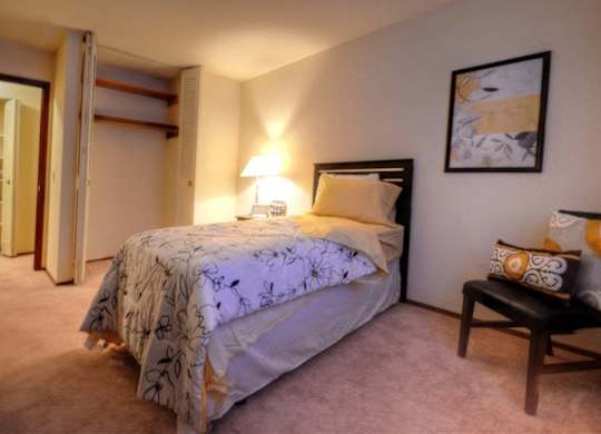 a bedroom with a bed and a chair and a closet