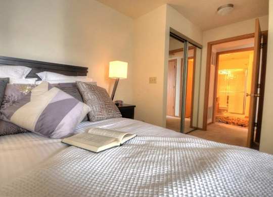 a bedroom with a bed with an open book on it