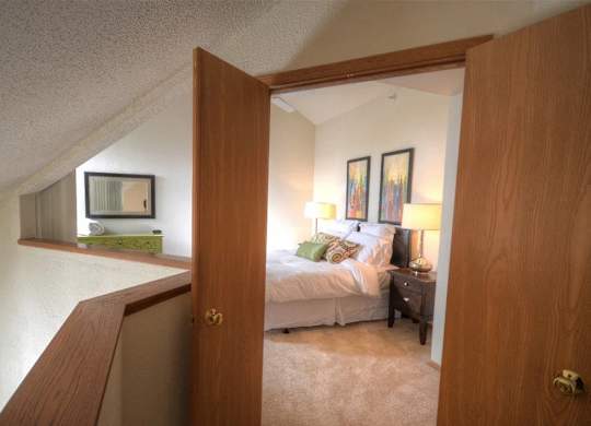 a bedroom with a bed and a mirror in a room
