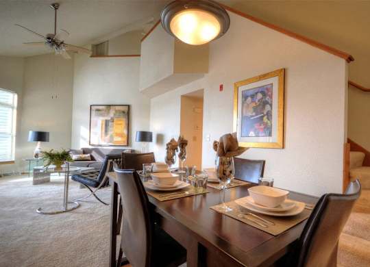 a dining room with a wooden table and chairs