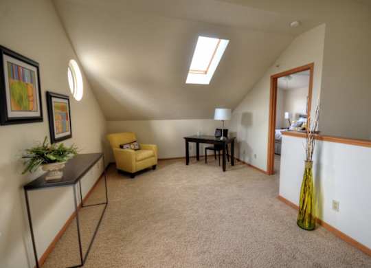 a living room with a couch and a table and a door to a dining room