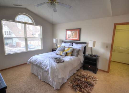a bedroom with a bed and a ceiling fan