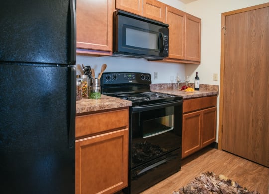 a kitchen with black appliances and wooden cabinets