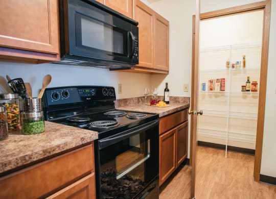 Kitchen with black appliances and walk-in pantry attached
