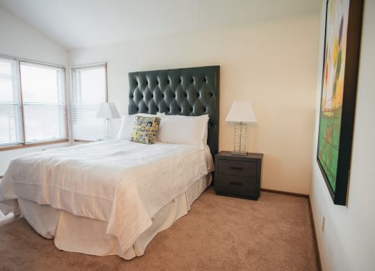 a bedroom with a white bed and a large window